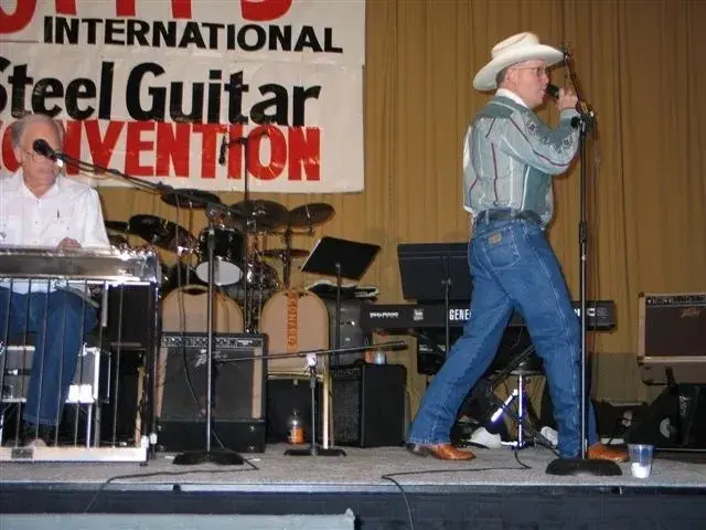 Two men in cowboy hats on stage image