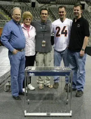 A group posing for a picture in front of an arena.