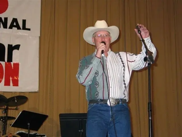 A man in a cowboy hat singing into a microphone.