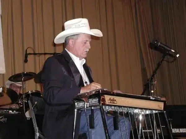 A man in a cowboy hat playing a musical instrument.