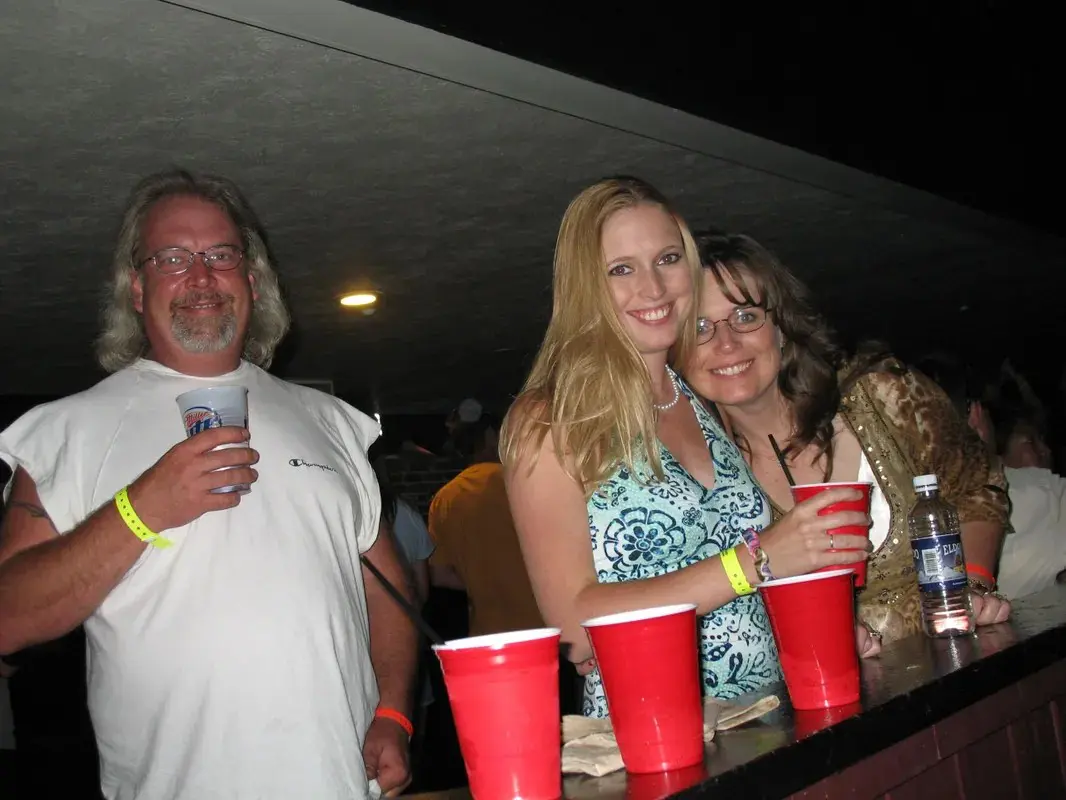 Three people posing for a picture at a bar.